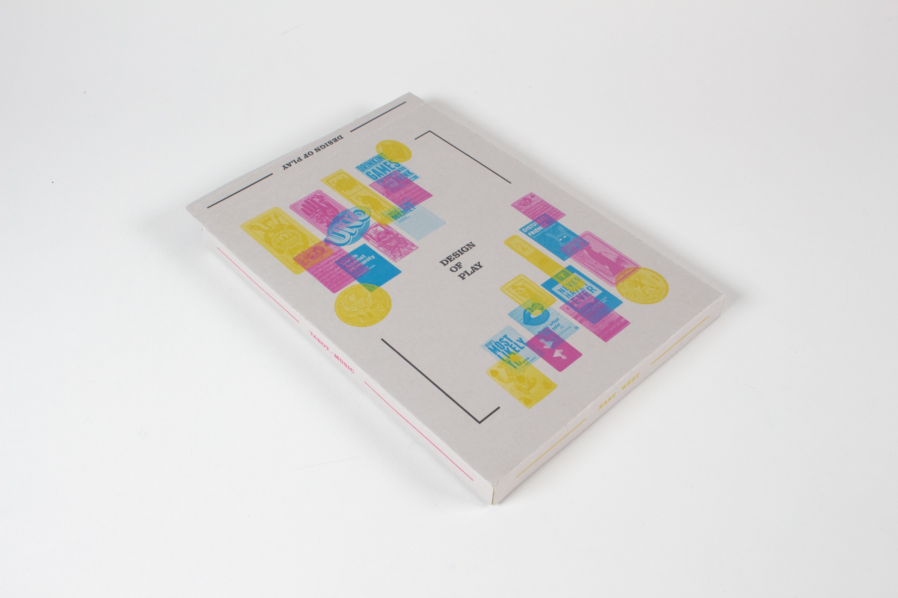 The slipcase lying flat on white, its cover printed with a grid of small yellow, magenta and blue rectangles inside a thin die-cut frame