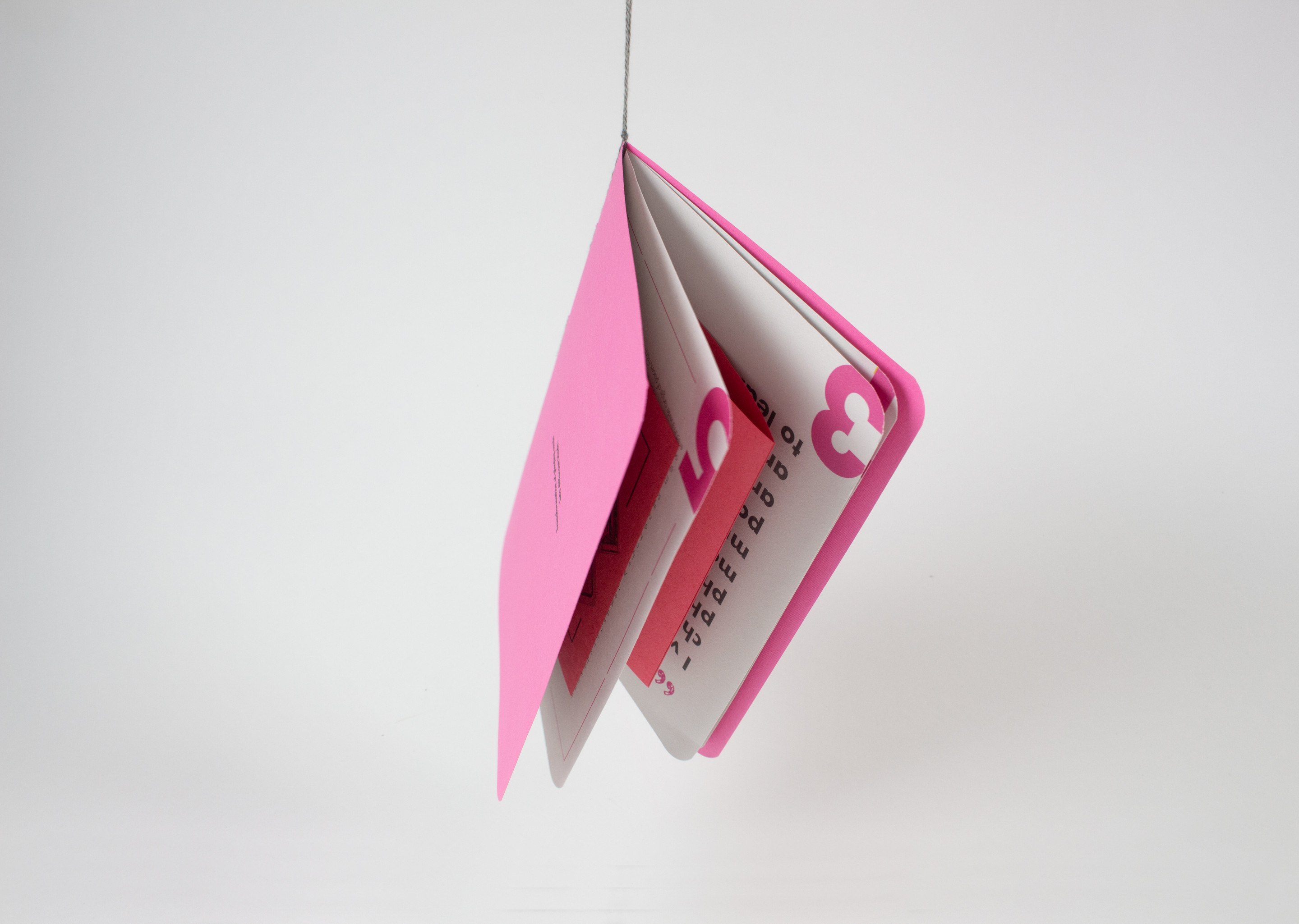 The magenta book stood open on its end, its pages fanned, the number 3 die-cut into the cover