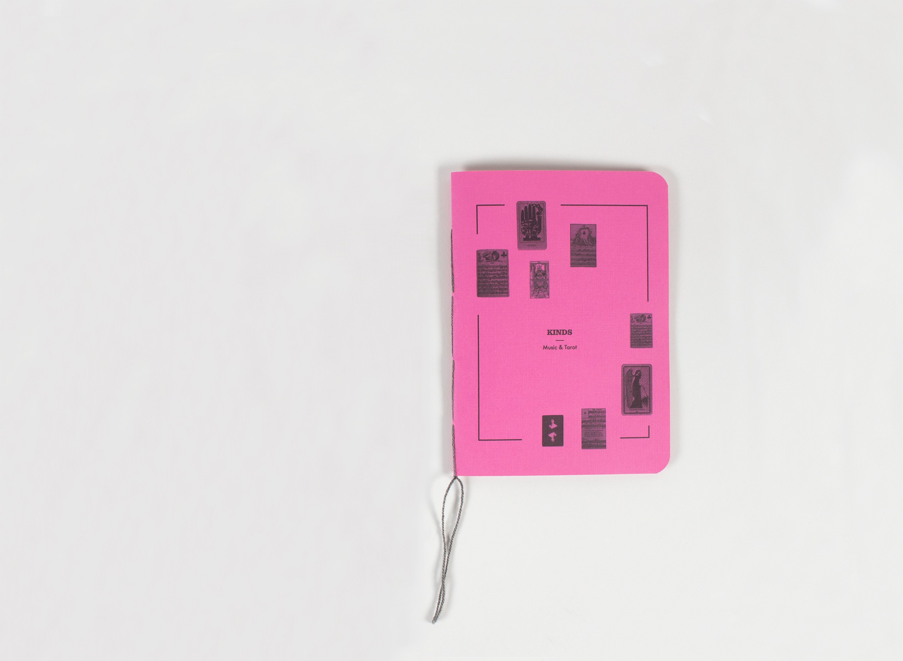 The magenta book closed and seen from above, the card-back diagram and its thread laid out flat