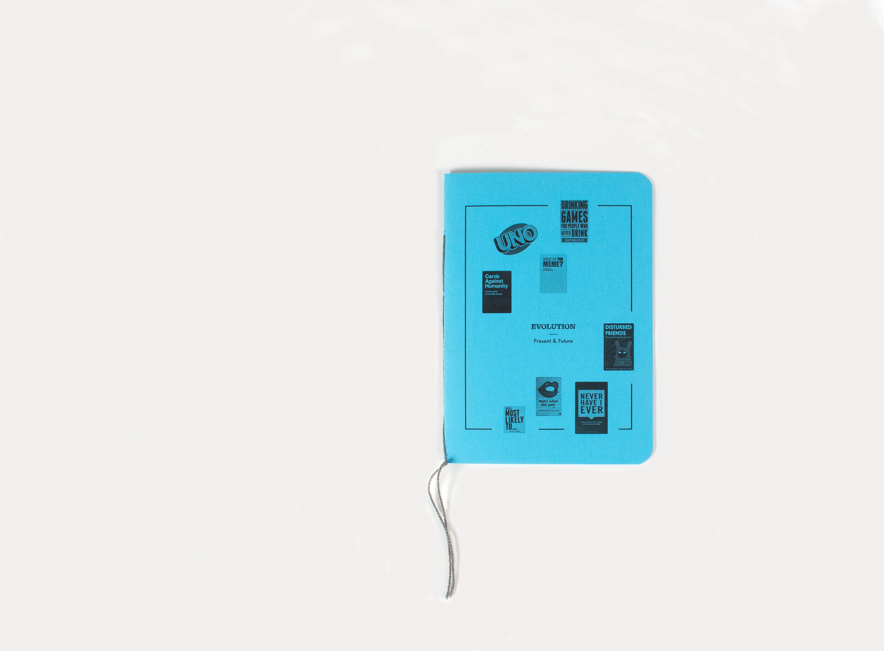 The blue book closed and seen from above, its card-back diagram and grey thread on white