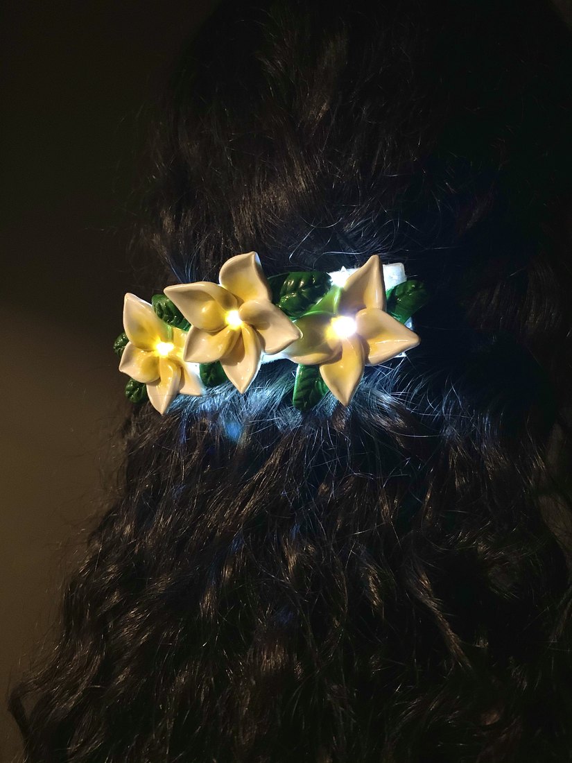 The lit clip close up in dark curly hair