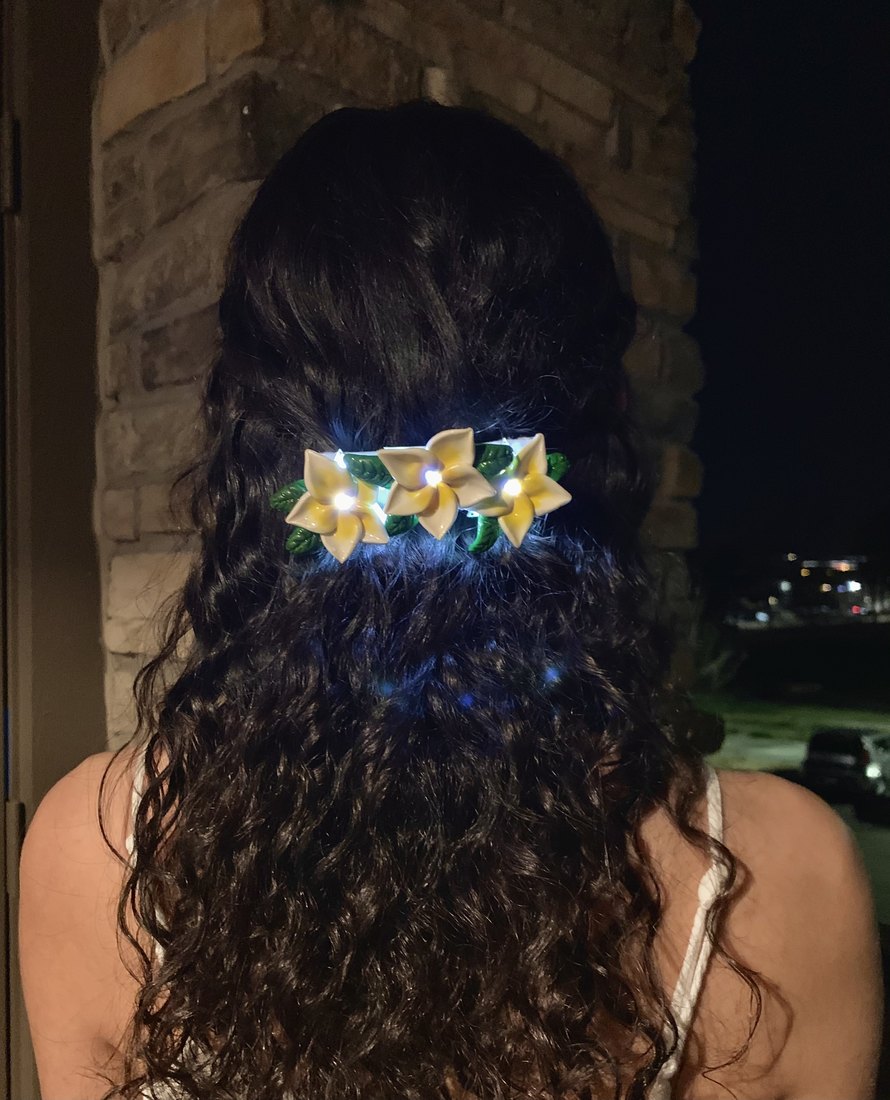 The frangipani clip worn, lit from within