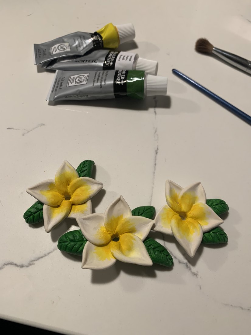 The finished flowers and leaves beside the paint tubes