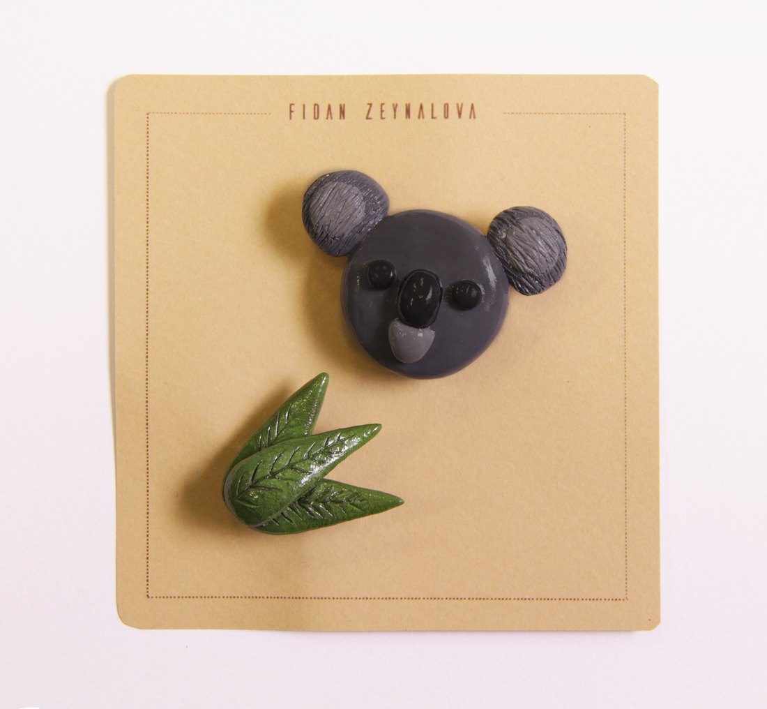 A koala face pin with eucalyptus leaves