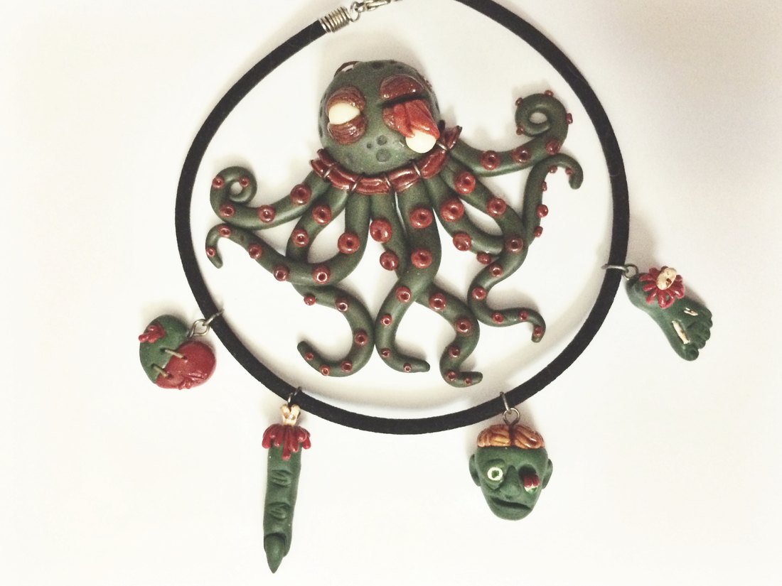 An octopus pendant on a cord, with two charms