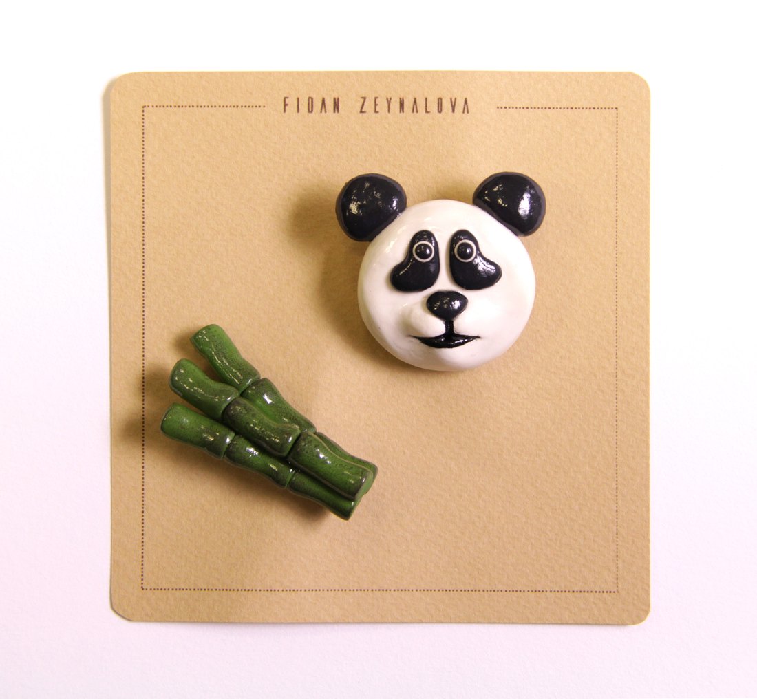 A panda face pin with bamboo stalks