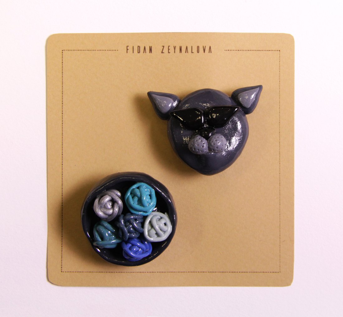 A purple pig face pin with a dish of marbled charms