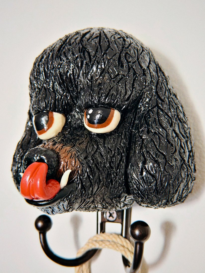 A black clay poodle head with its tongue out