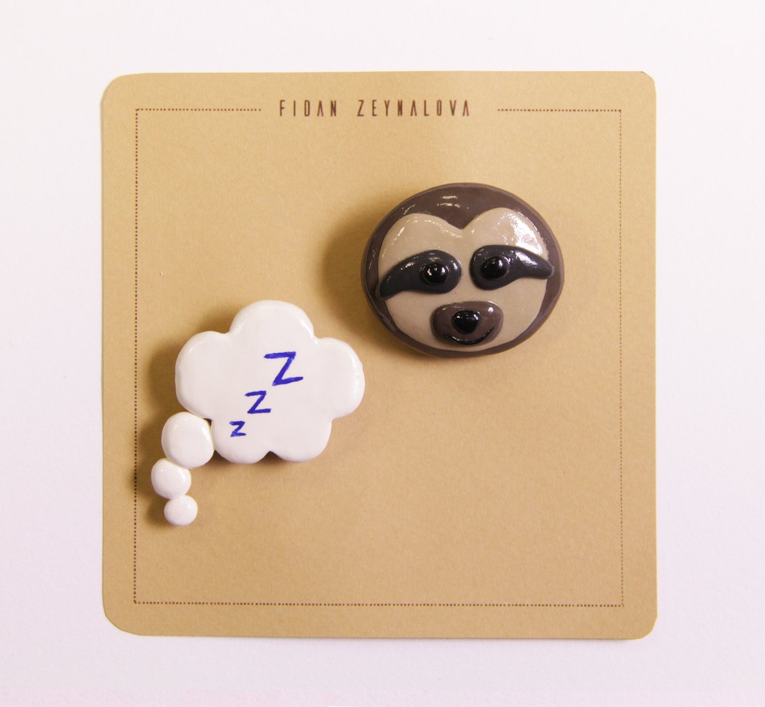 A sloth pin with a sleeping cloud
