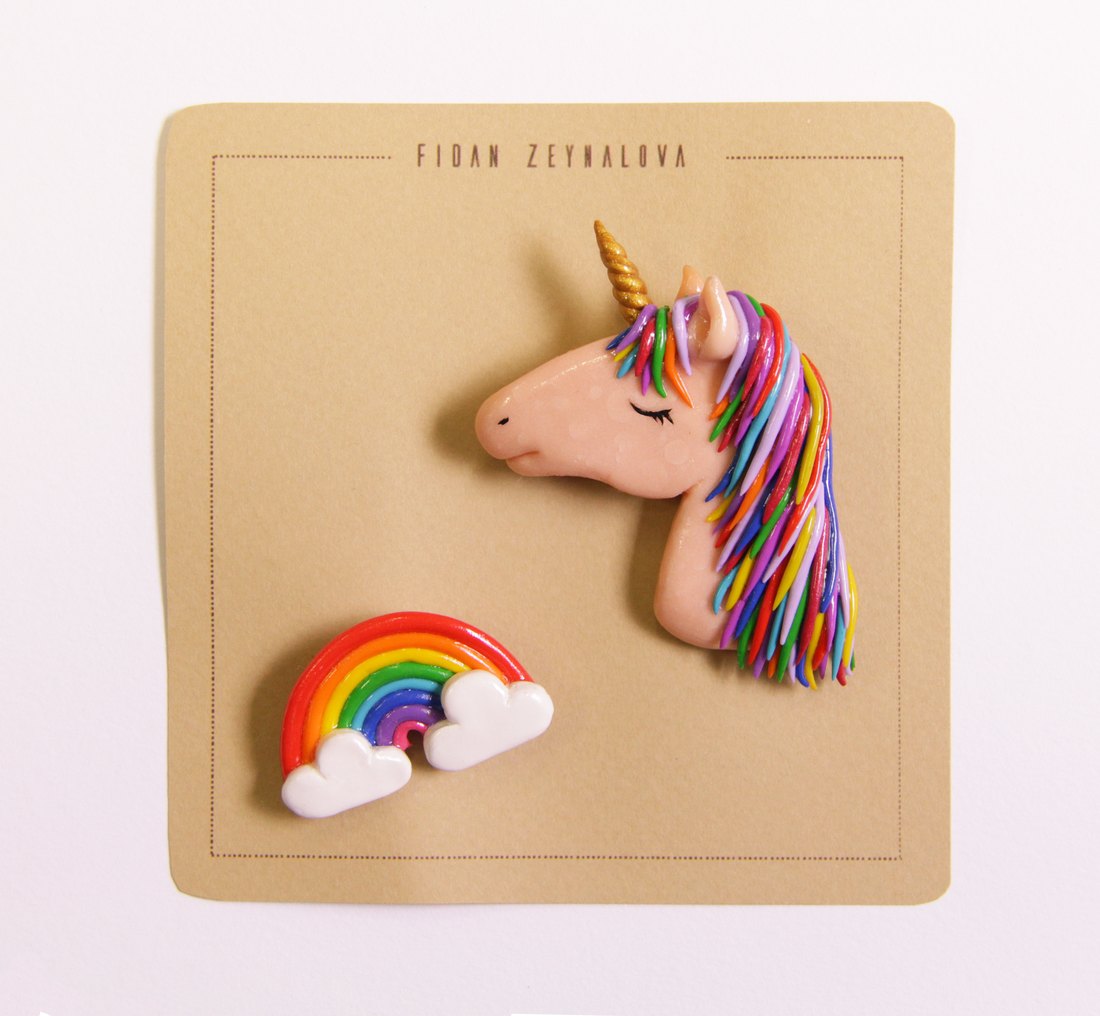 A unicorn pin with a rainbow mane, and a rainbow