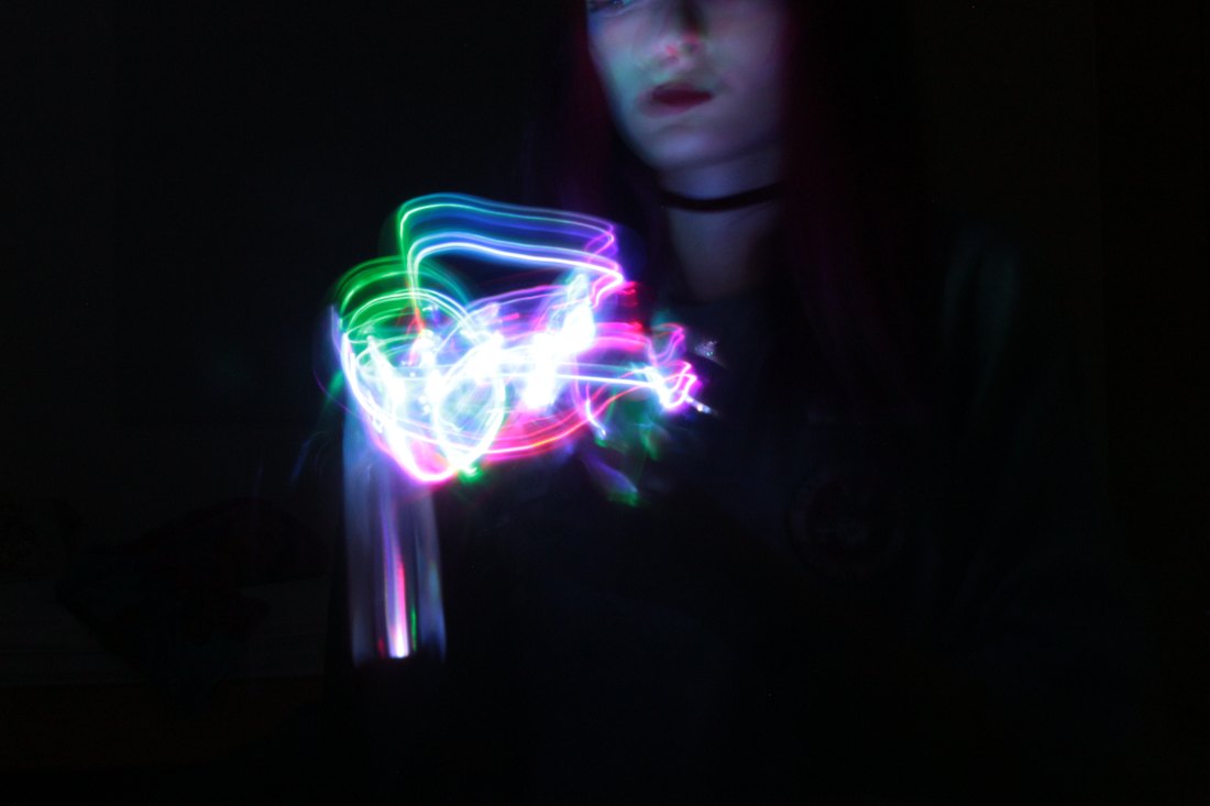 A tangle of white light drawn over a pair of hands