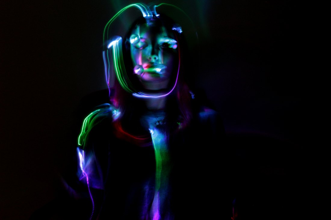A figure outlined in green light, arms raised