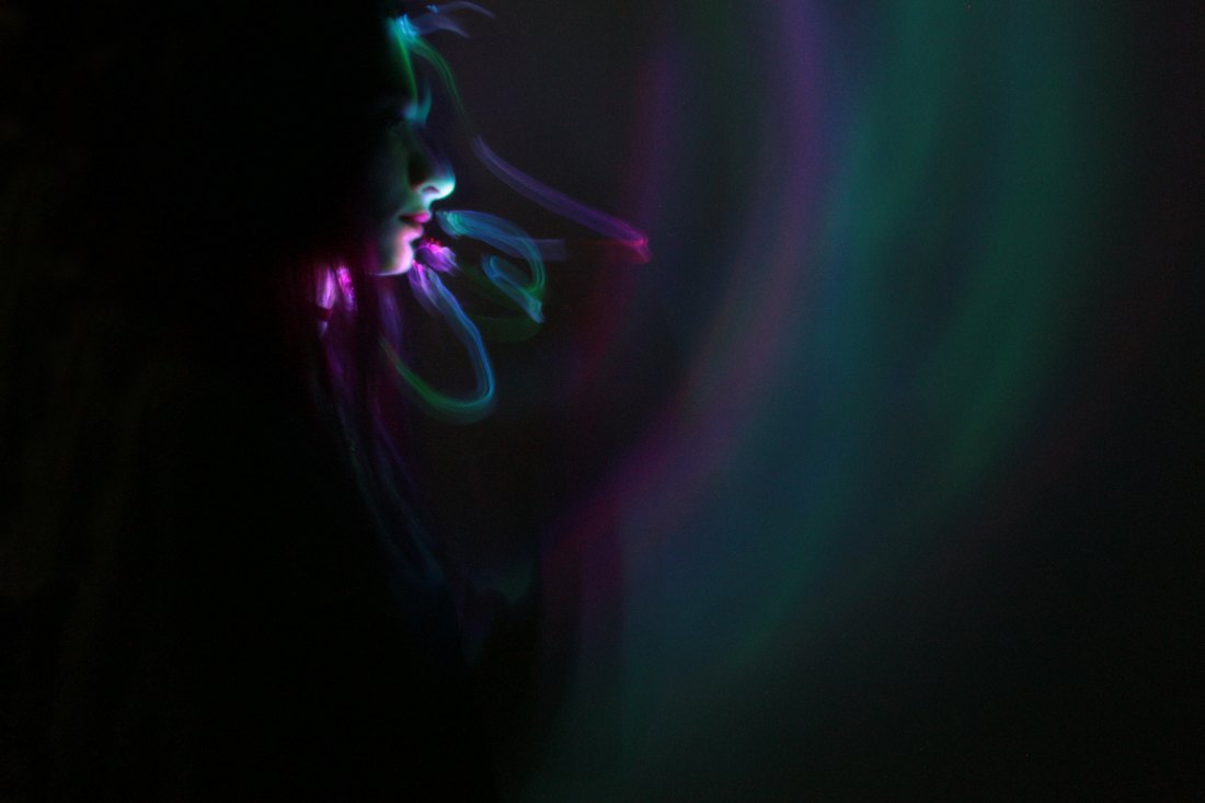 A soft green sweep of light beside a shoulder