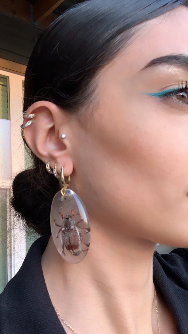 A beetle earring being worn