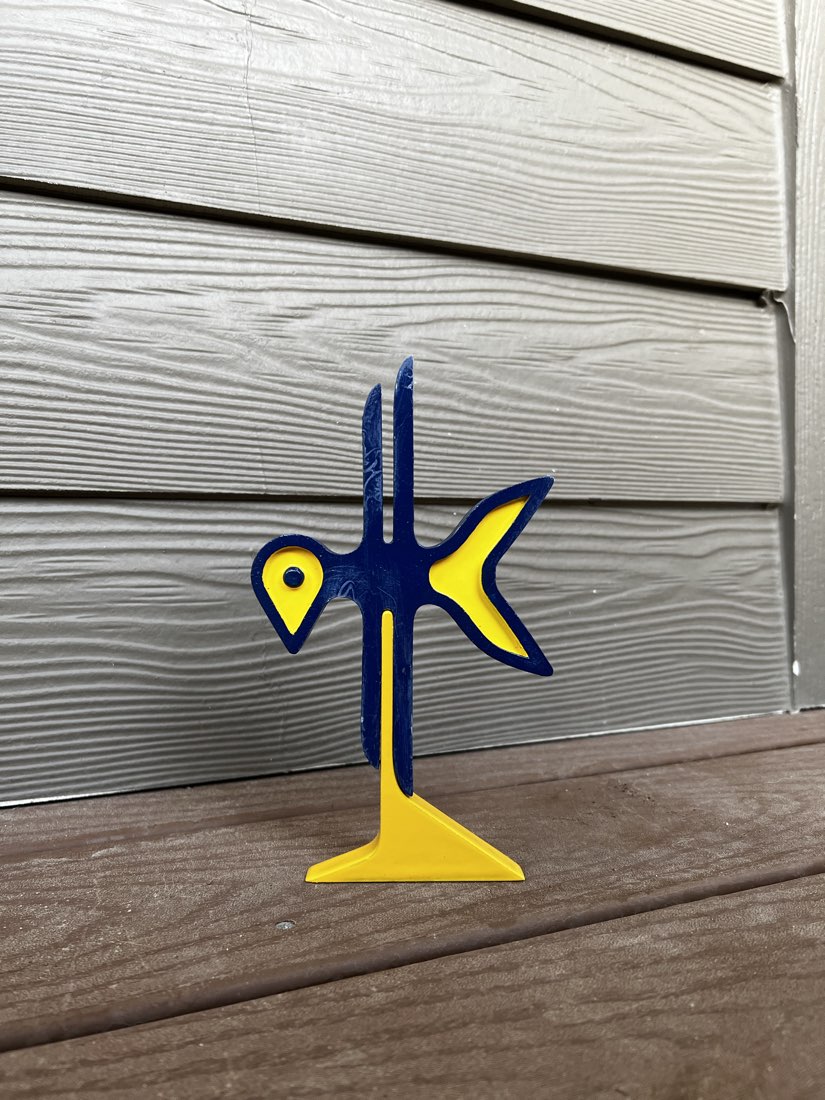The printed logo standing on its yellow base