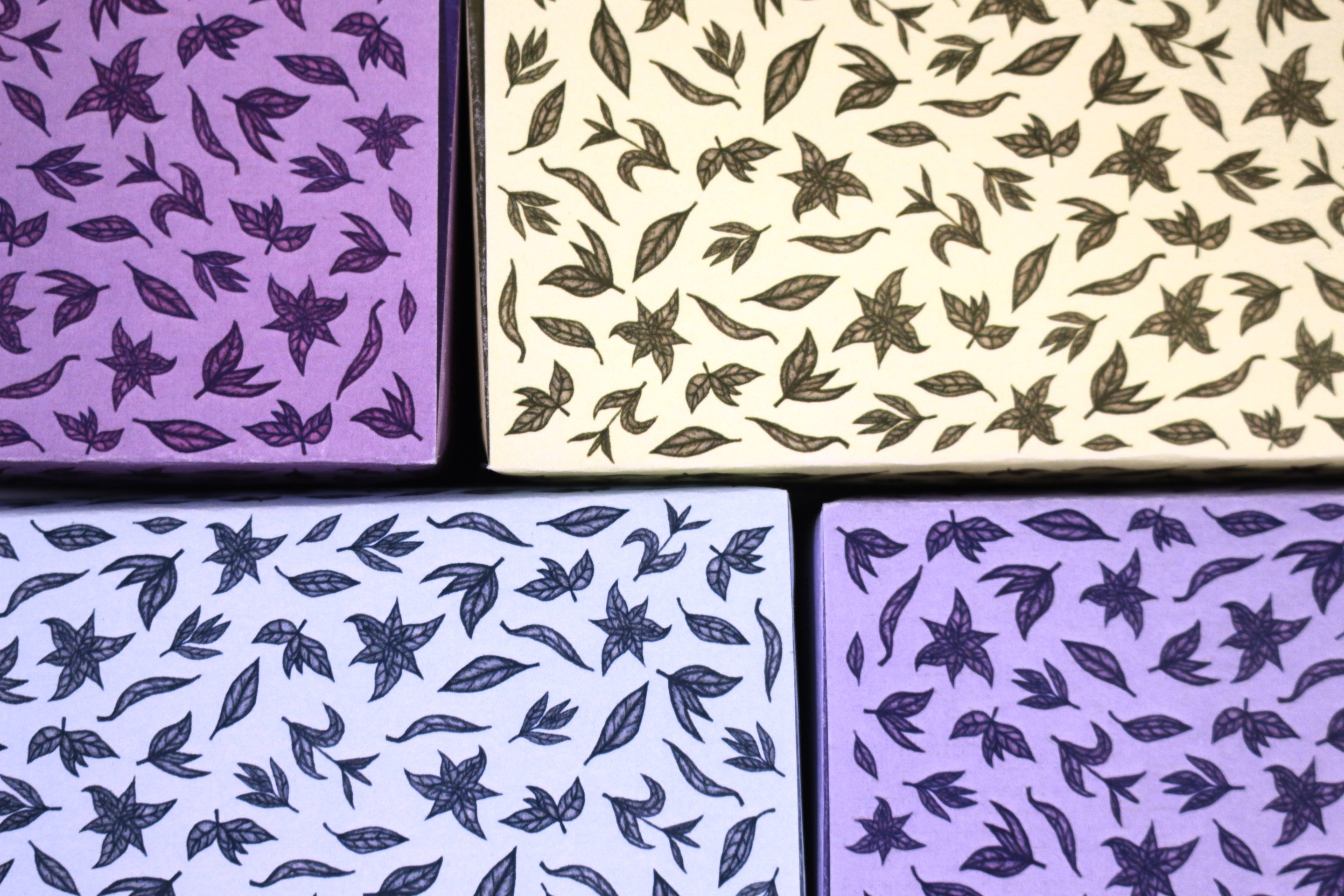 The four colourways as flat panels butted together: purple, cream, pale blue and lavender, each printed with the same drawn leaves and star-shaped flowers